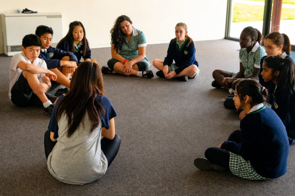 OSHC students sitting in a circle during an inclusive dance and movement workshop